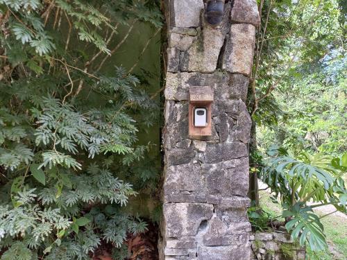 a stone wall with a bird house on it at Chalé Le Refuge in Teresópolis