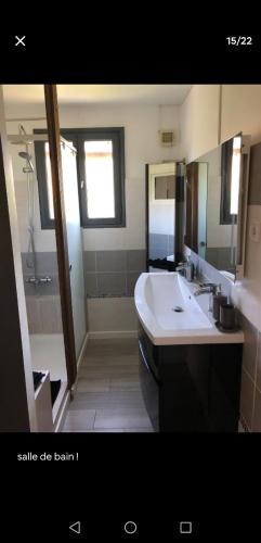 une salle de bain avec une baignoire, un lavabo et un miroir dans l'établissement Grand studio 6 personnes terrasse parking, à Toulon