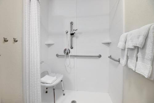 a white bathroom with a shower and a sink at Candlewood Suites Waco by IHG in Waco