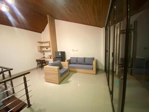 a living room with a blue couch and a table at SONGOKU HOUSE APARTMEN in Pesanggaran