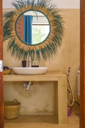 a bathroom with a sink and a mirror on a counter at Maracuja villa Zanzibar in Bwejuu