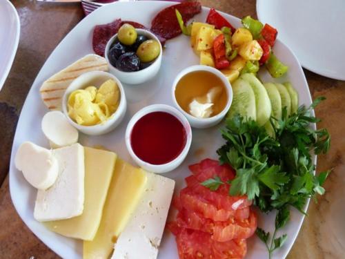 a plate of food with different types of cheese and fruit at Madrigal Boutıque Hotel in Istanbul