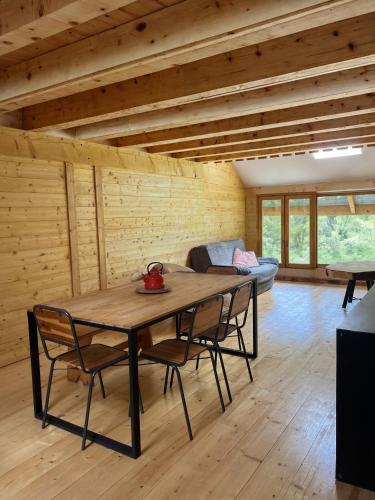 une salle à manger avec une table et des chaises en bois dans l'établissement L'Ostal, à Les Combes