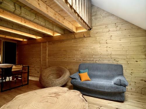 a living room with a blue chair and a table at L'Ostal in Les Combes