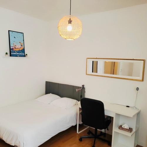 une chambre avec un lit, un bureau et une chaise dans l'établissement Le Studio du Port de La Rochelle RDC, à La Rochelle