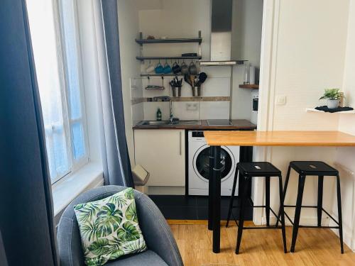 une cuisine avec une table et deux tabourets à côté d'un comptoir dans l'établissement Le Studio du Port de La Rochelle RDC, à La Rochelle