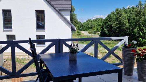 a blue table on the balcony of a house at Ferienwohnung Katzensprung Jonsdorf in Kurort Jonsdorf