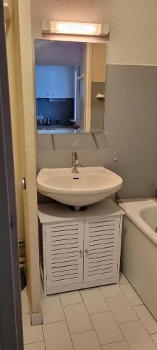 une salle de bain avec un lavabo, un miroir et une baignoire dans l'établissement Studio cabine climatisé avec parking au Couchant, à La Grande Motte