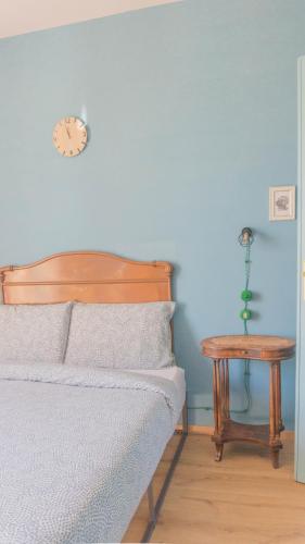 a bedroom with a bed and a table with a clock at Il Biru in Montelupo Albese