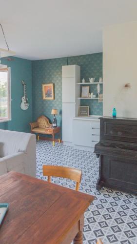 a living room with a table and a piano at Il Biru in Montelupo Albese