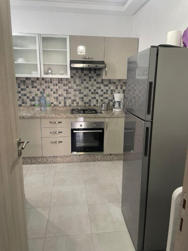 a kitchen with a stainless steel refrigerator and a stove at Appartement Costa Mar Martil in Martil