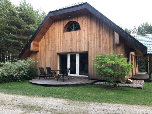 a cabin with a table and chairs in front of it at Pakaso sodyba in Kirdeikiai