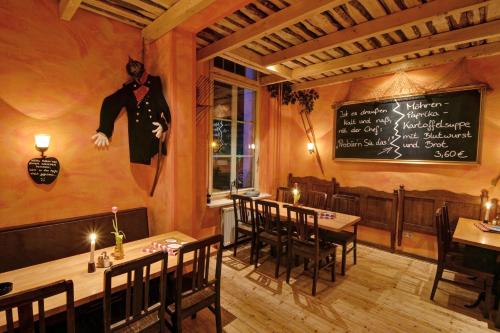 a restaurant with tables and a chalkboard on the wall at Hotel Villa Wirtshaus Köpenick in Hofgeismar