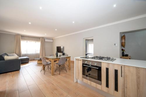 a kitchen and living room with a stove and a table at Utopia on the Rock2 in Nelspruit