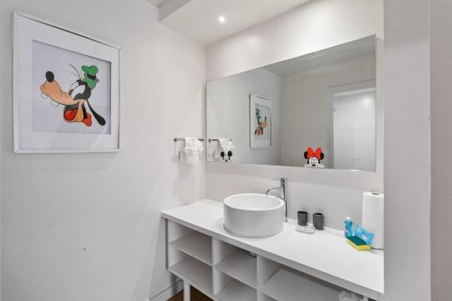 a white bathroom with a sink and a mirror at 11 Condo-Hotel With Double Bed And Community Pool Miles From Disney! in Kissimmee