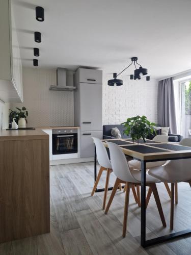 a kitchen and dining room with a table and chairs at Apartament w Choczewie in Choczewo