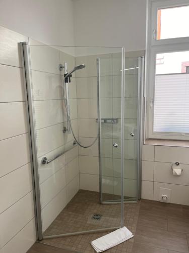 a shower with a glass door in a bathroom at Apartment Van Eß Hof - Altstadt Warburg in Warburg