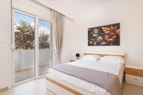 a bedroom with a bed and a large window at Gennadi Villa Mare in Gennadi
