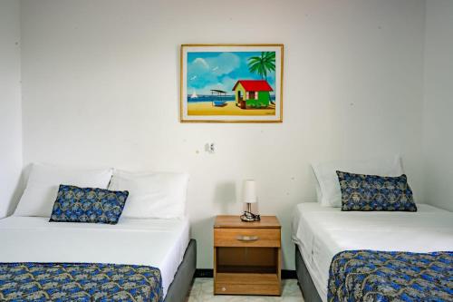 a room with two beds and a picture on the wall at Hotel El Pirata Morgan in Providencia