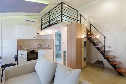 a living room with a couch and a spiral staircase at Step rooms apt spa in Belgrade