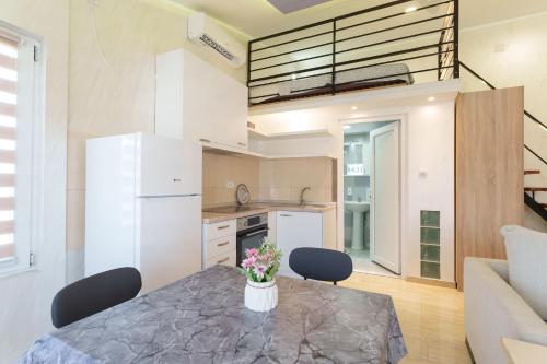 a kitchen and living room with a table and chairs at Step rooms apt spa in Belgrade