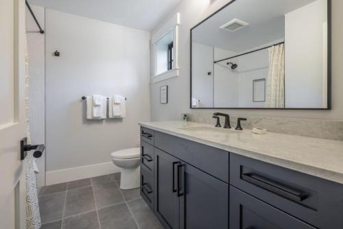 a bathroom with a sink and a toilet and a mirror at Suncadia 6 Bdrm Pet Friendly Home Great for Large Families in Cle Elum
