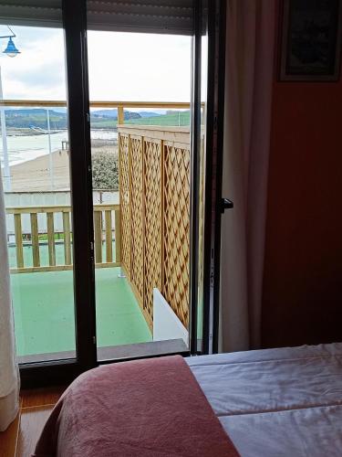 a bedroom with a door open to a balcony with a view at Nuevo Hotel Sydney in Suances