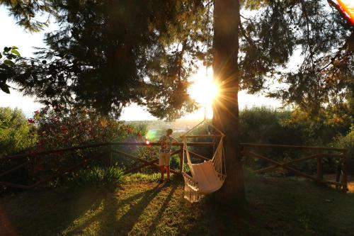 a person sitting in a hammock under a tree at Antico Portale in Ascea