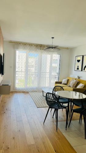 un salon avec une table et un canapé dans l'établissement Bel appartement à 5 mn de Paris très proche Métro 13 et 14, à Saint-Ouen
