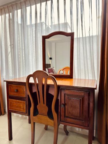 a wooden desk with a chair and a mirror at Hotel Tiwintza Internacional in Quito