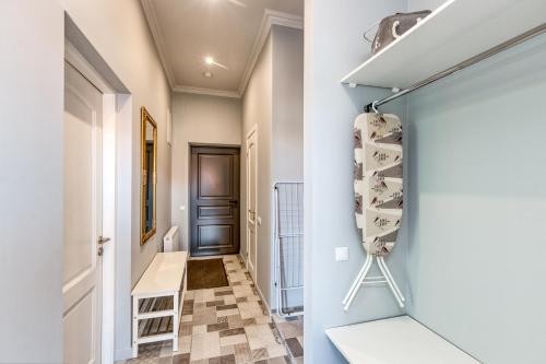 a hallway with white walls and a closet with shelves at Apartments Vitenberg in Cēsis