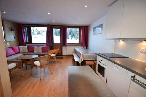 une cuisine et un salon avec un canapé et une table dans l'établissement Résidence Le Makalu - 3 Pièces 6/7 pers - LE MAKALU - PLAGNE CENTRE MAE-5974, à Aime La Plagne