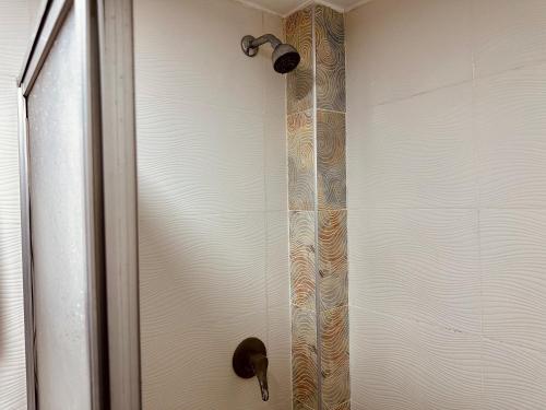 a shower door with a shower head in a bathroom at Hotel Tiwintza Internacional in Quito