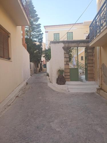 an empty alley with a building and a potted plant at Lalos Apartment in Egina