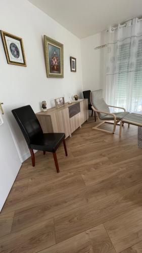 Una sala de estar con una silla y una mesa. en Appartement 15 min Paris Gare du Nord, en Deuil-la-Barre