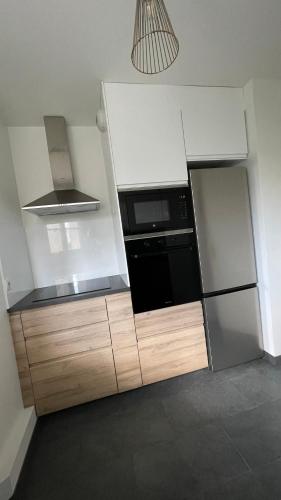 una cocina con nevera y microondas en Appartement 15 min Paris Gare du Nord, en Deuil-la-Barre