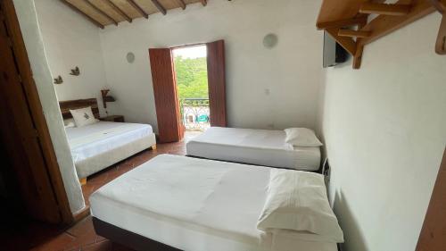 a room with two beds and a window at Hotel Victoria Barichara in Barichara