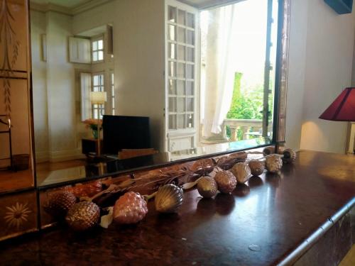 une pièce avec un miroir et des coquillages sur une table dans l'établissement La chambre du Château de Puisseguin, à Puisseguin