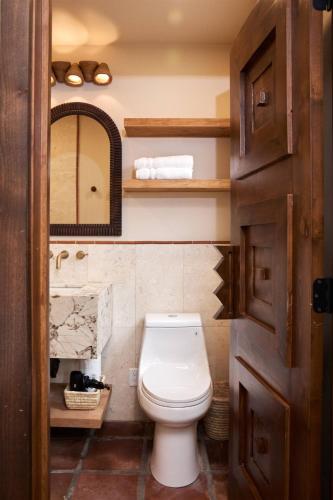 a bathroom with a toilet and a mirror at Sand Castle in Imperial Beach