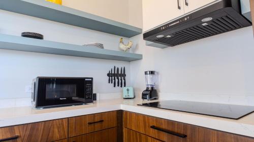 a kitchen with a microwave and a stove top oven at Suites Miramar14 in Ensenada
