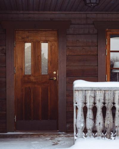 a door of a house with snow on the porch at Lofsdalens Fjällhotell & Hotellbyns Lägenheter in Lofsdalen