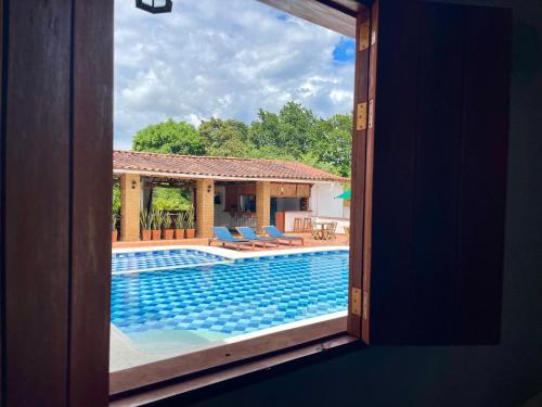a view of a swimming pool through a window at Hotel Victoria Barichara in Barichara
