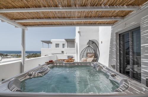 a hot tub on the balcony of a house at My Naxos seaview apartment in Agia Anna Naxos