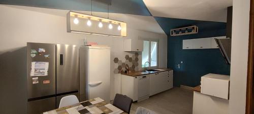 une cuisine avec un réfrigérateur et une table à l'intérieur dans l'établissement Maison avec Piscine Tour de France le 11 et 12 Juillet, à Villeneuve-sur-Lot