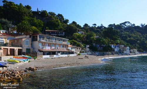 une plage avec un groupe de bâtiments à côté de l'eau dans l'établissement Studio avec balcon - Plage à 10min à pied, au Pradet