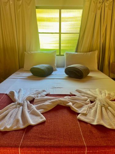 a white bed with two pillows on top of it at Hotel Fazenda Rancho Mineiro in Engenheiro Paulo de Frontin