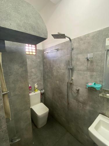 a bathroom with a toilet and a shower and a sink at Beachfront Bliss Home Stay in Hambantota