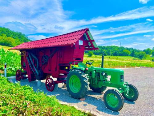 a toy tractor with a red shed on display at Etno selo Stanojevic in Boljevac
