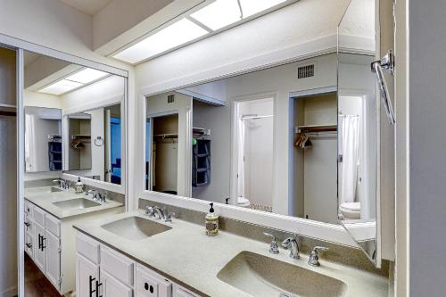 a bathroom with two sinks and two mirrors at Desert Sky in Tempe