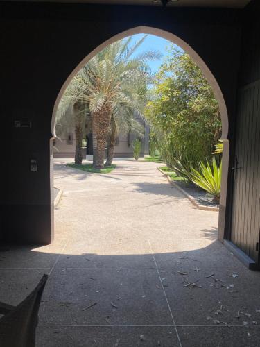 an archway leading into a courtyard with palm trees at Villa Mano in Marrakech